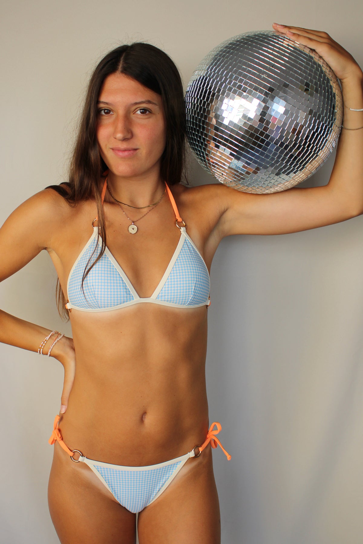 Modelo con bikini estampado azul vichy con tiras intercambiables color naranja
