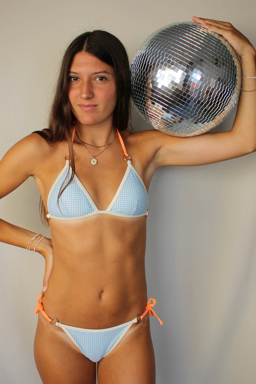 Modelo con bikini estampado azul vichy con tiras intercambiables color naranja
