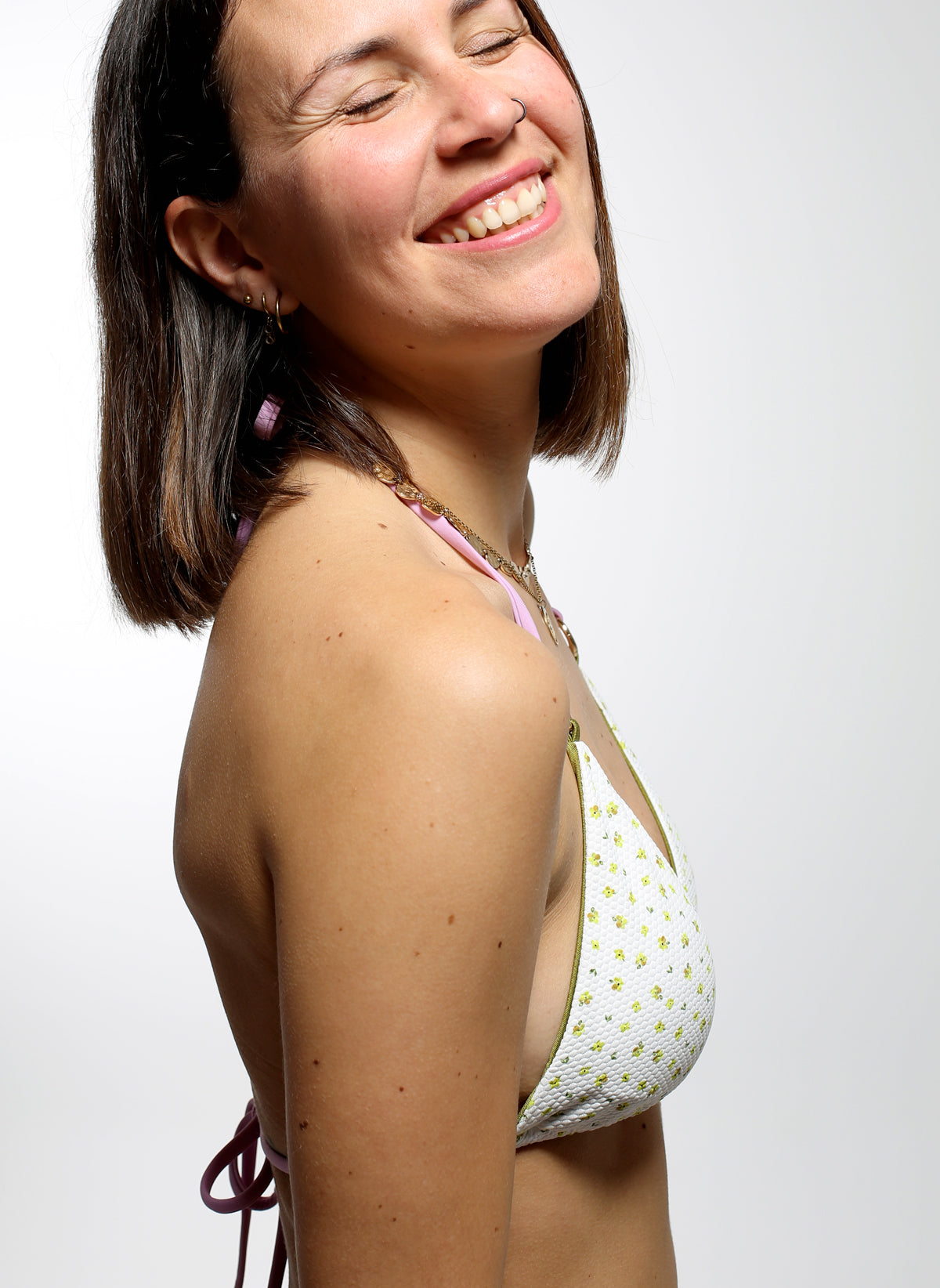 Modelo con bikini reversible verde y blanco con tiras intercambiables lilas